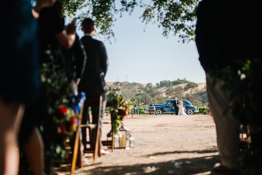 Bride exiting classic car before walking down the isle at Cass Winery in Paso Robles by San Luis Obispo wedding photographer Austyn Elizabeth Photography