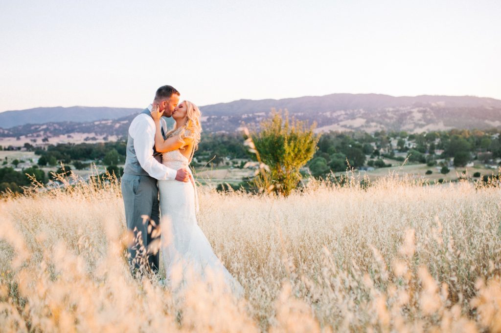 Bride and groom on hill with mountains in background Bride and Groom at Sunset at Grace Maralyn Estates and Garden Wedding by Austyn Elizabeth Photography