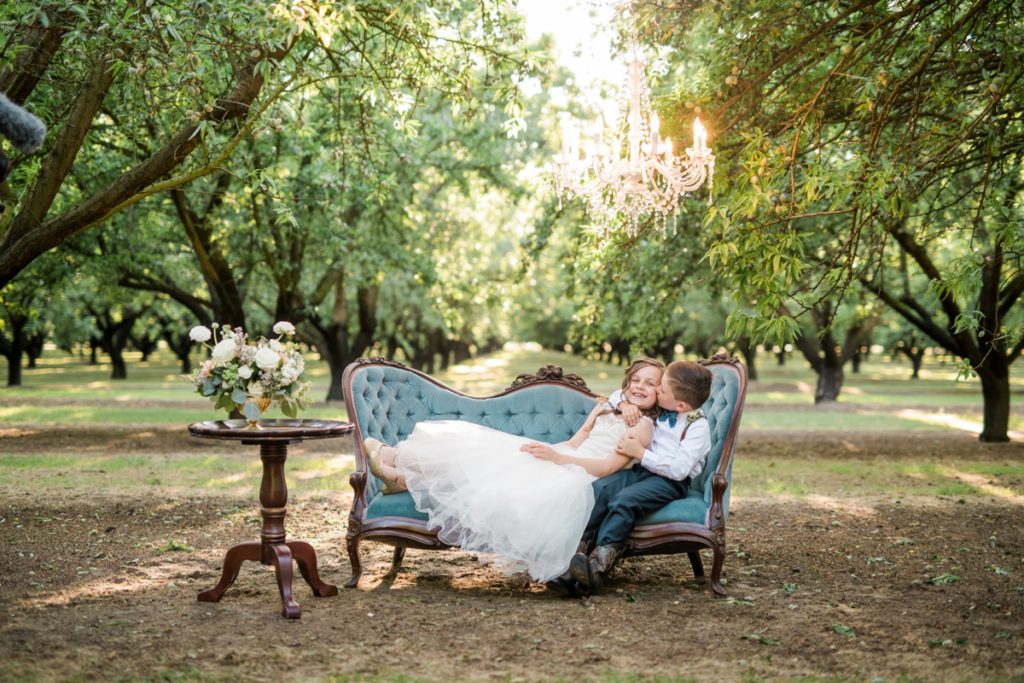 Bride and Groom's son and daughter on vintage couch in at Almond Grove Wedding by Paso Robles Wedding Photographer Austyn Elizabeth Ford