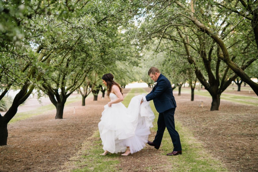 Bride and groom walking in almond orchard by SLO Wedding Photographers Austyn Elizabeth Photography