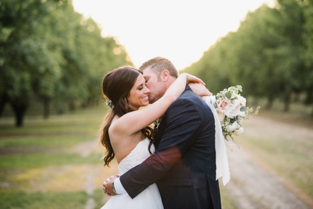 Bride and groom in almond orchard at sunset by SLO Wedding Photographers Austyn Elizabeth Photography