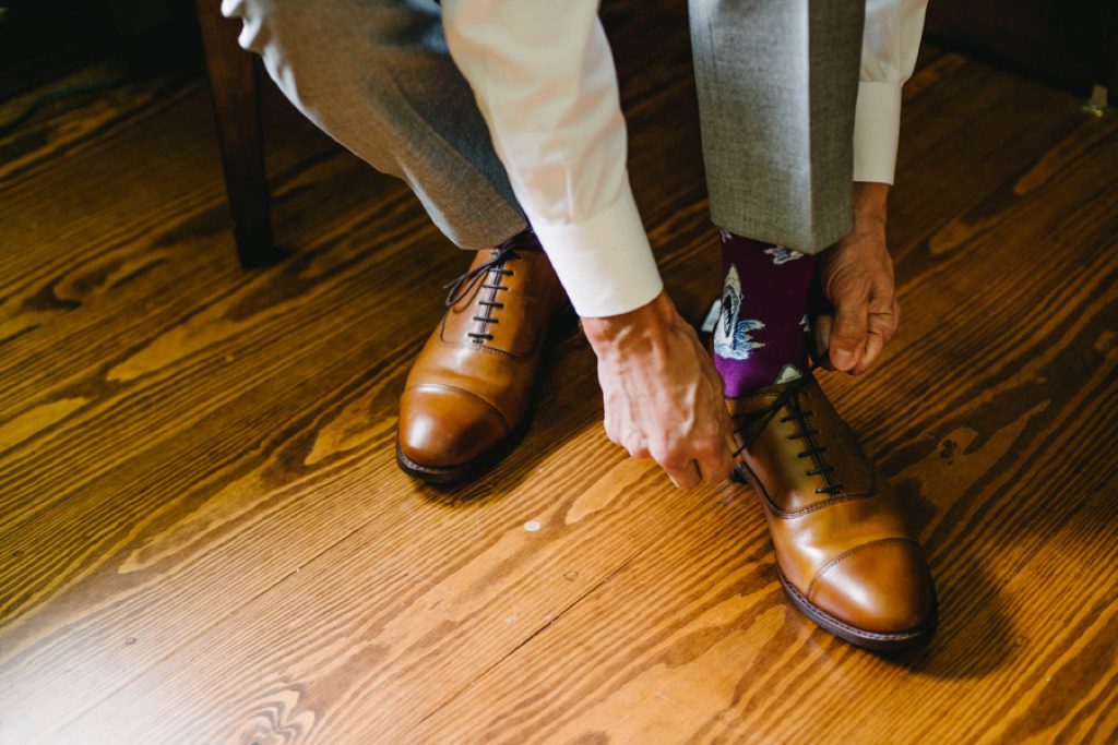 groom tieing shoes at lyons farmette wedding by austyn elizabeth