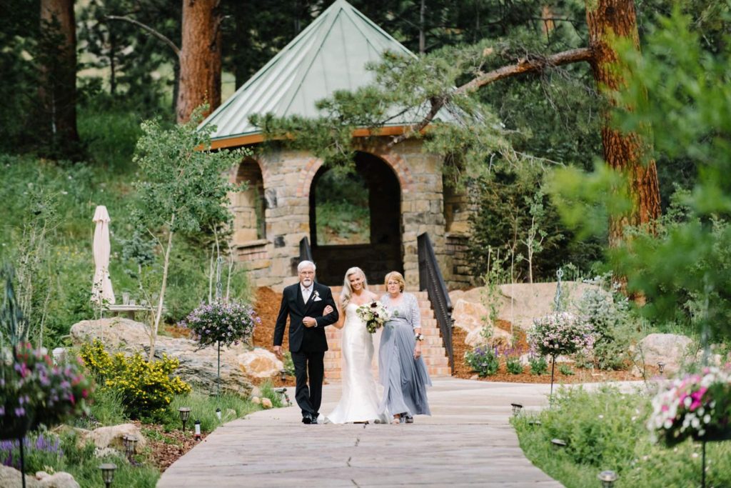 Bride walking with mom and dad down the isle at Mountain Wedding in Estes Park at Della Terra by Estes Park Wedding Photographer Austyn Elizabeth Photography