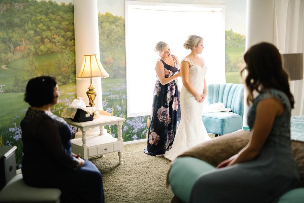 Mother of the bride assisting bride with wedding dress at Noland Castle Pismo Beach Wedding Photographer Austyn Elizabeth Photography