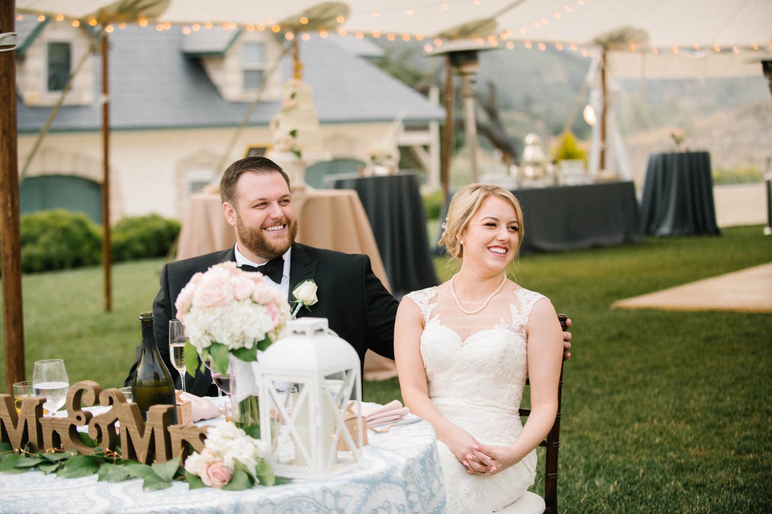 Bride and groom at sweetheart table during reception at Noland Castle Wedding by SLO Wedding Photographer Austyn Elizabeth Photography.