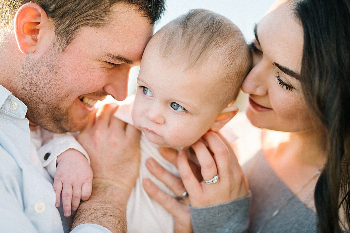 mom and dad smiles at one year old with Pismo Beach Family Photographer Austyn Elizabeth Photography