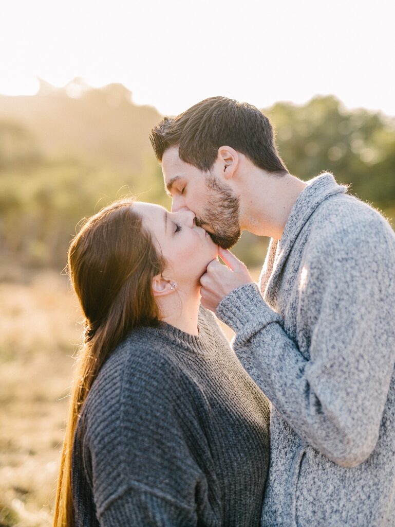 Husband kisses his wife by lifting her chin in golden field for a family mini session by Arroyo Grande Family photographer Austyn Elizabeth Photography