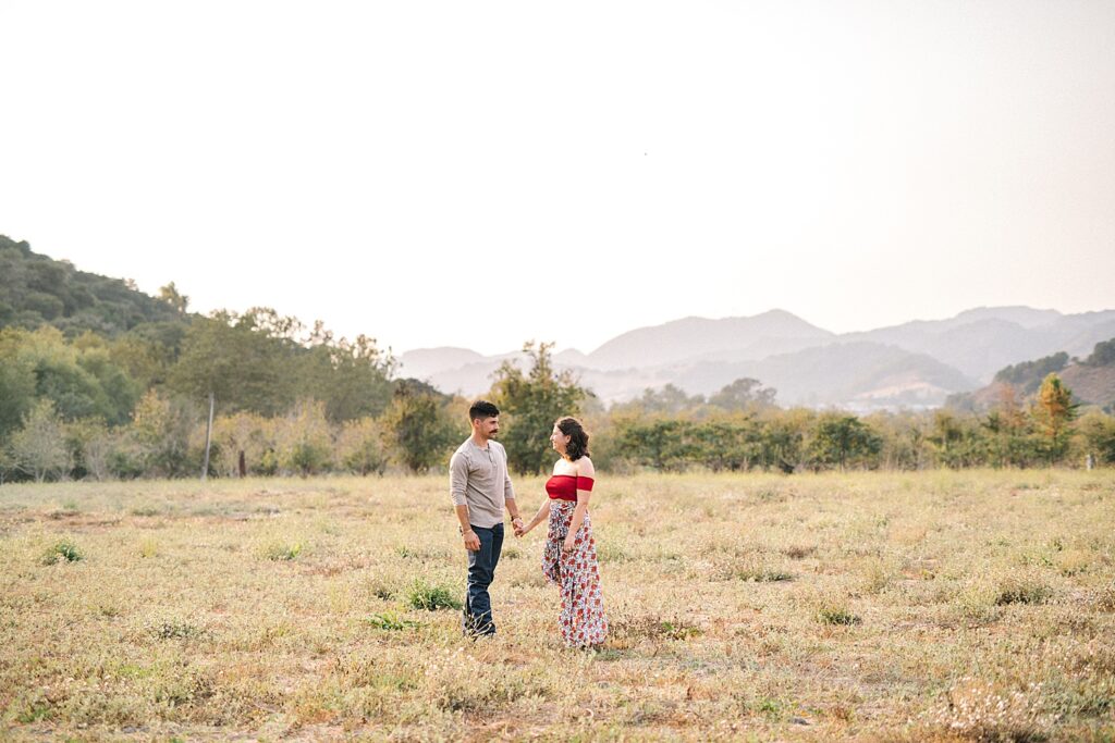 Standing in a field with smoke filled hills at Avila Barn Engagement Session with Avila Beach Engagement Photographer Austyn Elizabeth Photography