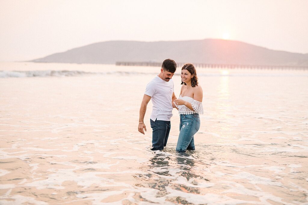 Couple standing in the water during their Avila Beach engagement session by Avila Beach engagement photographer Austyn Elizabeth Photography