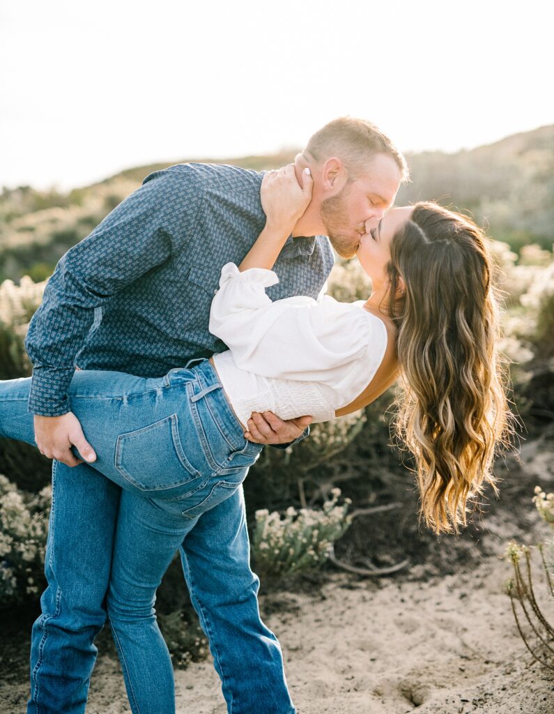 Guy dips girl during engagement session on Pismo Beach Dunes by Pismo Beach Engagement Photographer Austyn Elizabeth Photography