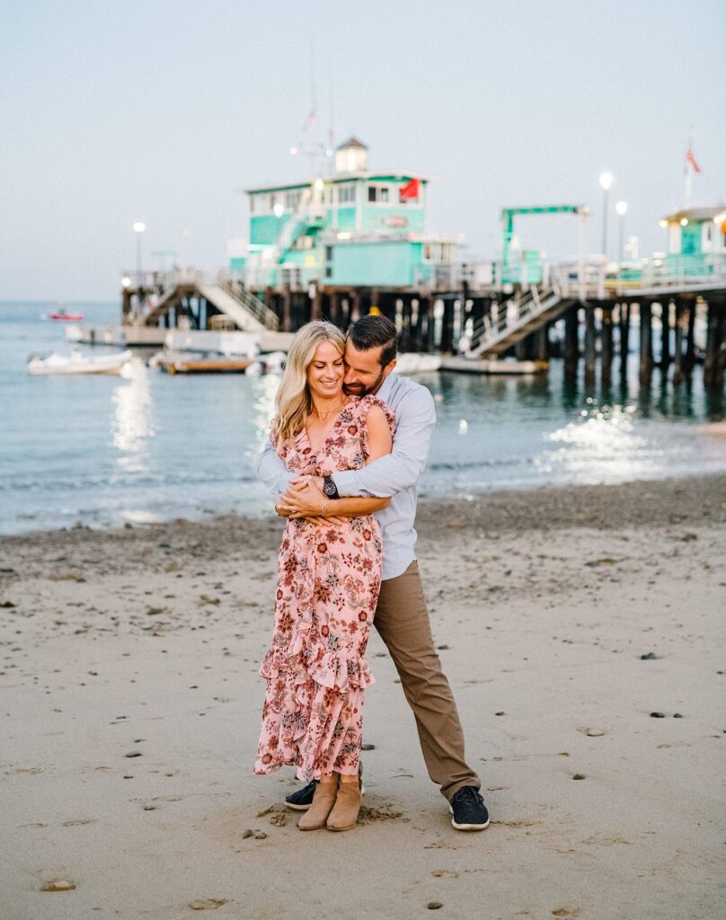 Groom holding bride with pleasure pier in the background by Catalina Wedding Photographer Austyn Elizabeth Photography
