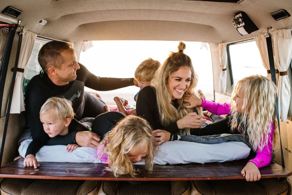 Family of six all piled up tickling each other in VW Westfalia for Family adventure photo session with Pismo beach family photographer Austyn Elizabeth Photography