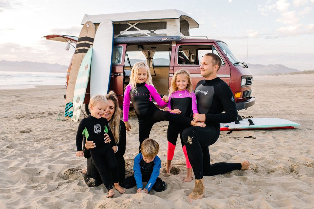 family of six in wetsuits at Pismo beach with surfboards and a VW Westy at sunset by Pismo beach Family photographer Austyn Elizabeth Photography