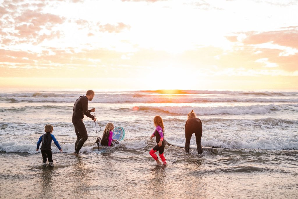 Family of six goes surfing at sunset by pismo beach family photographer Austyn Elizabeth Photography
