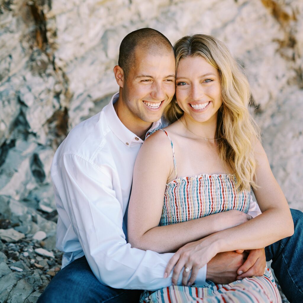 Newly engaged boyfriend wraps arms around his fiance at surprise proposal at Montana De Oro's Spooners Cove by Pismo beach engagement photographer austyn elizabeth photography