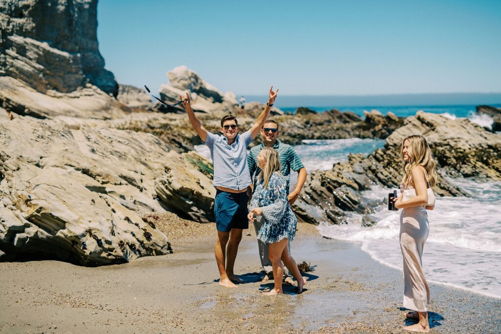 Friends celebrate friends at surprise proposal at Montana De Oro's Spooners Cove by Pismo beach engagement photographer austyn elizabeth photography