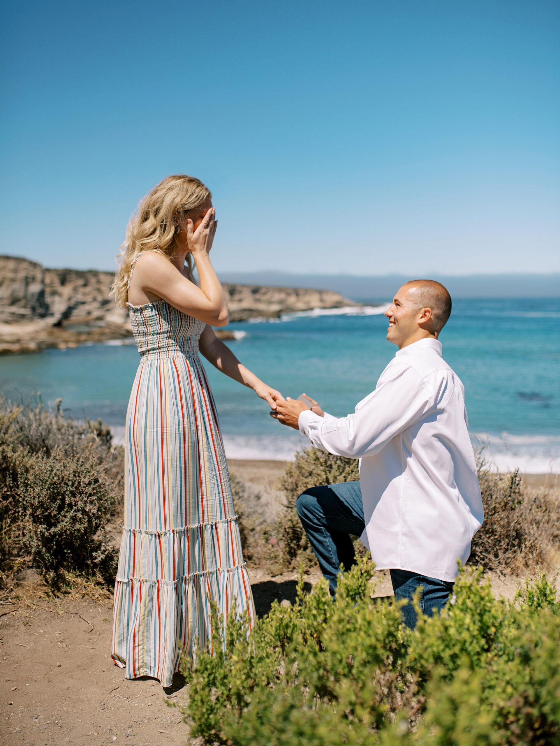 tears and covering her face at surprise proposal at Montana De Oro's Spooners Cove by Pismo beach engagement photographer austyn elizabeth photography