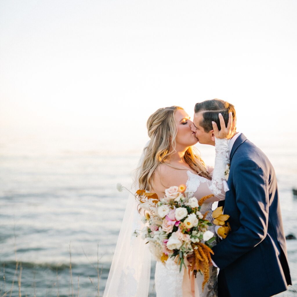 Kissing at sunset by the cayucos bluffs at California autumn coastal wedding at Cass House Cayucos Wedding by Pismo Beach Wedding Photographer Austyn Elizabeth Photography