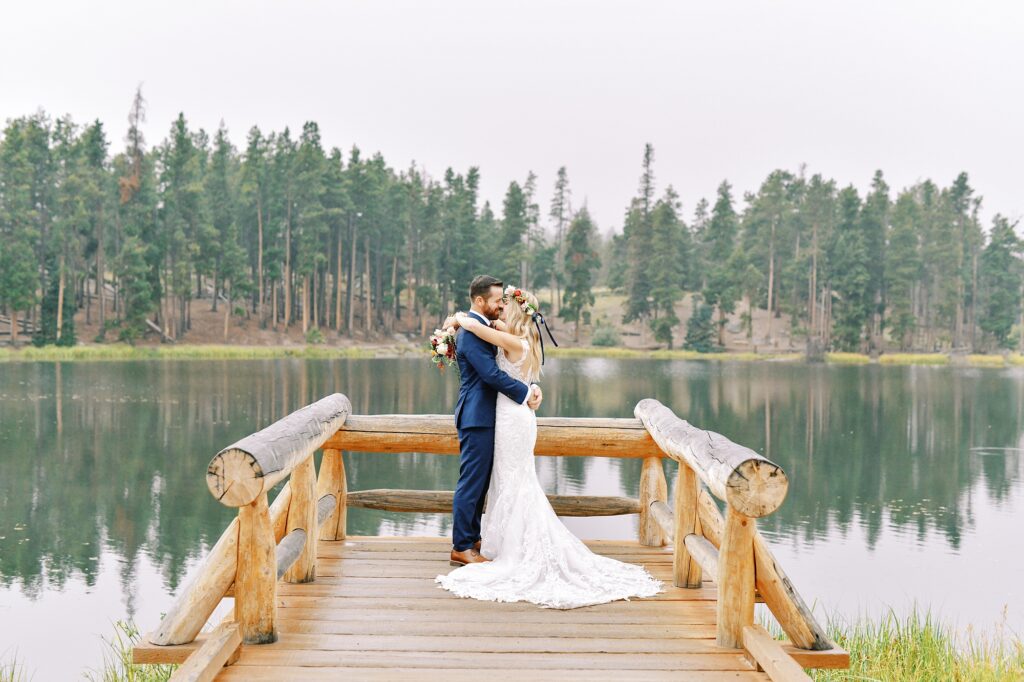 Couple on dock over Sprague Lake at Destination Rocky Mountain National Forest Wedding by Estes park Wedding Photographer Austyn Elizabeth Photography