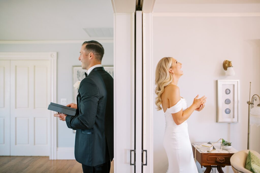 Groom laughs after receiving surprise black book from bride before wedding ceremony at Lamoure Vineyard wedding at Le Reve Estate by Pismo Beach wedding photographer Austyn Elizabeth Photography