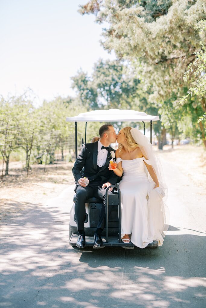 Couple kiss on golf cart at Lamoure Vineyard wedding by Pismo Beach wedding photographer Austyn Elizabeth Photography