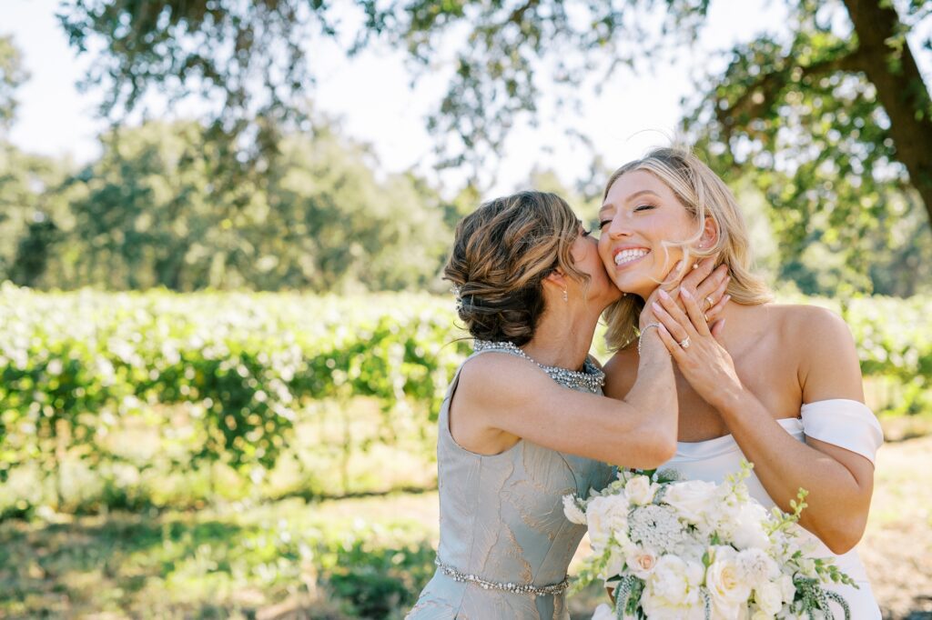 Grooms mom kisses bride's cheak at Lamoure Vineyard wedding by Pismo Beach wedding photographer Austyn Elizabeth Photography