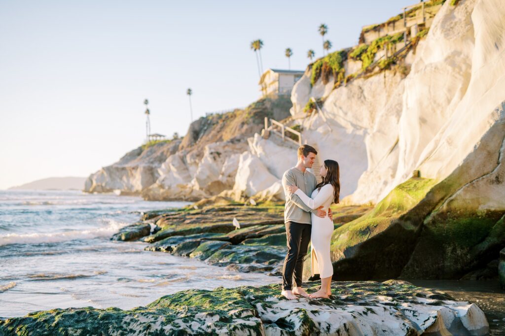 Couple stands on rock with white cliffs in background at Pismo Beach Engagement session by Pismo Beach Wedding Photographer Austyn Elizabeth Photography