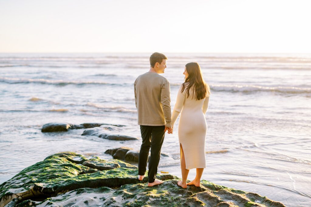 Standing on rock hand in hand at Pismo Beach Engagement session by Pismo Beach Engagement Photographer Austyn Elizabeth Photography