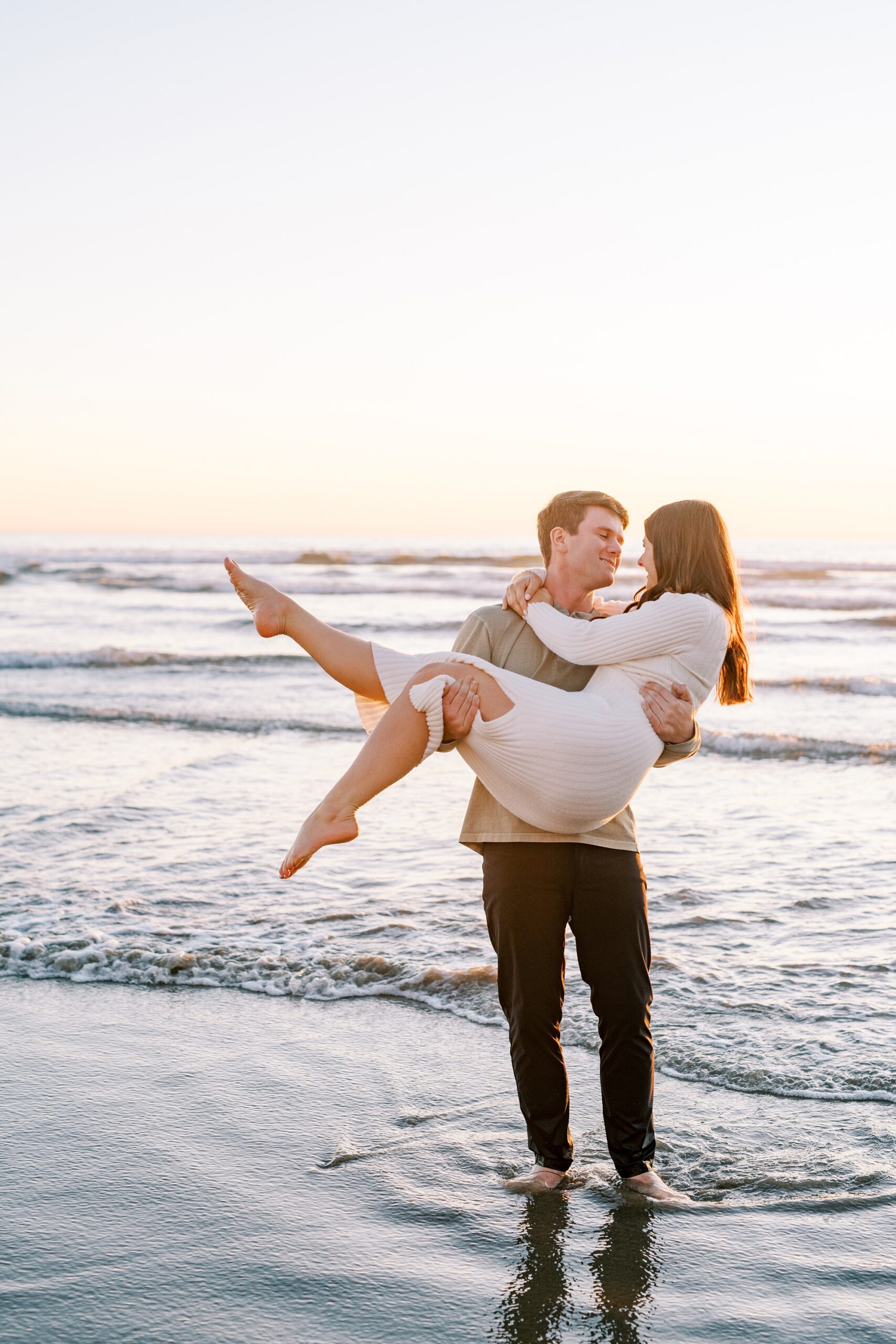 Newly engaged couple guy lifts girl in his arms at Pismo Beach Engagement session by Pismo Beach Portrait Photographer Austyn Elizabeth Photography