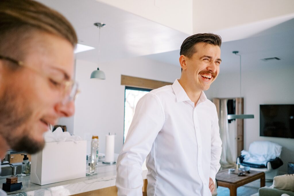 Groom smiling in dining room at Villa Leche wedding by Palm Springs Wedding Photographer Austyn Elizabeth Photography