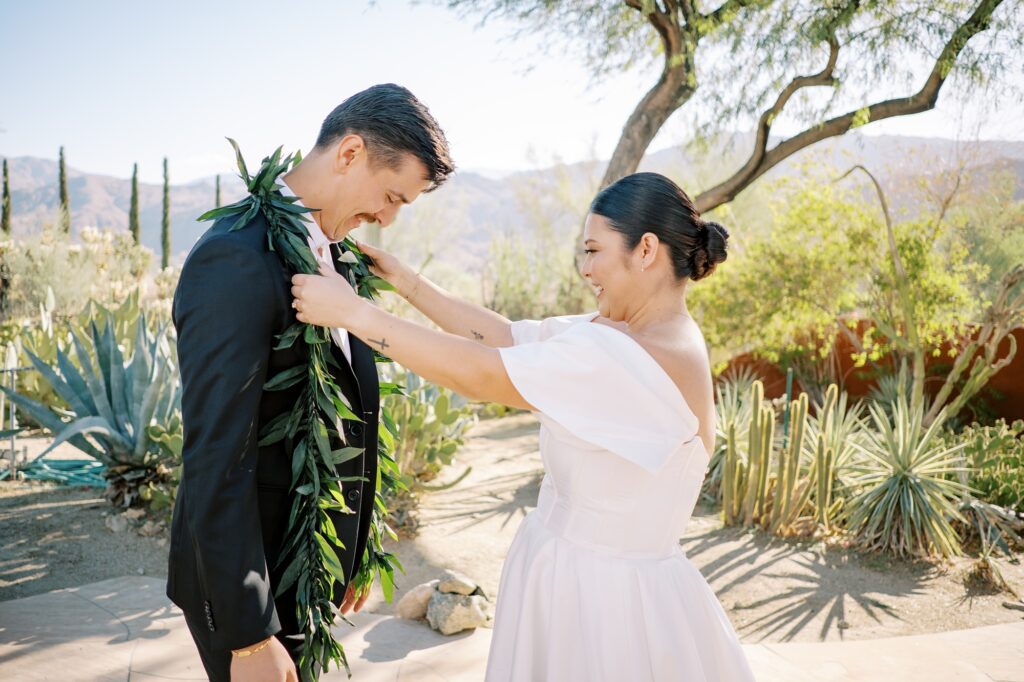 Hawaiian bride putting lei on husband before ceremony at hawaiian wedding held at Villa Leche wedding by Palm Springs Wedding Photographer Austyn Elizabeth Photography