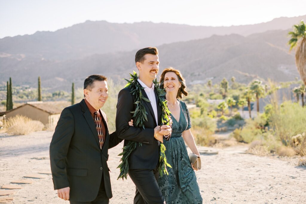 Groom walks with mom and dad down aisle at Villa Leche wedding by Palm Springs Wedding Photographer Austyn Elizabeth Photography