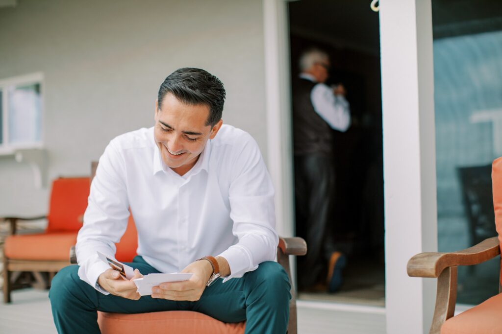 Groom reads photo box cards before wedding day telling their story by Cayucos Wedding Photographer on Film by Austyn Elizabeth Photography