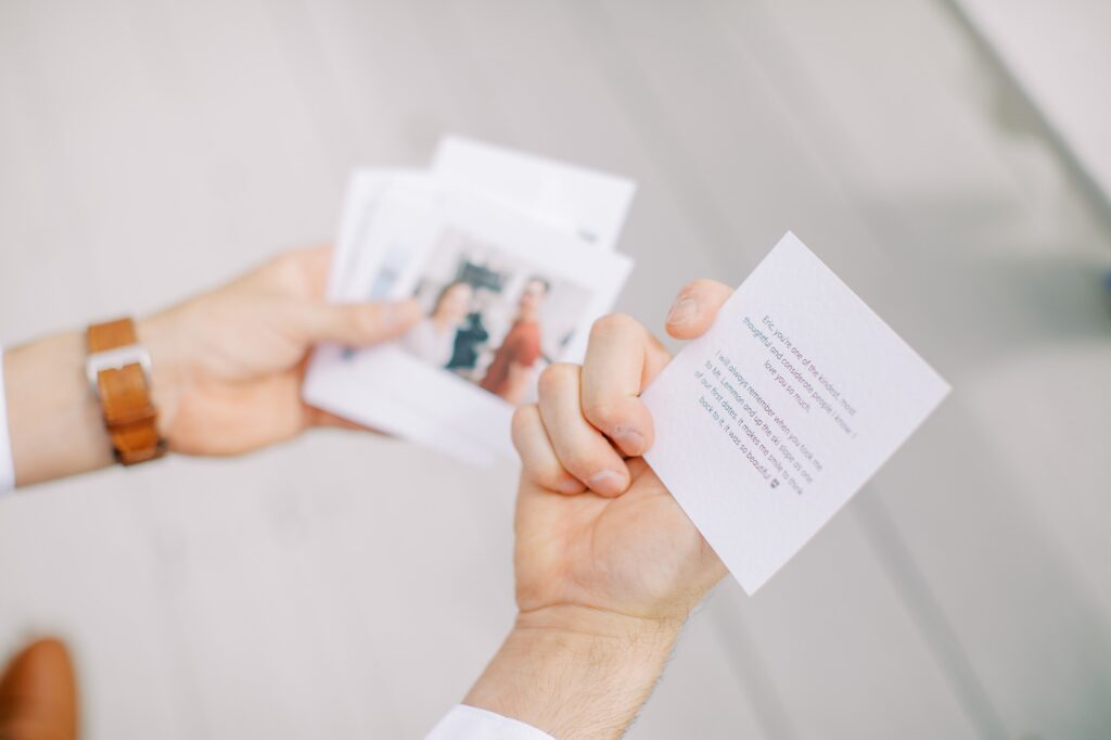 Detail of groom looking at cute photos and story notes from the bride before their wedding day by Cayucos Wedding Photographer on Film by Austyn Elizabeth Photography