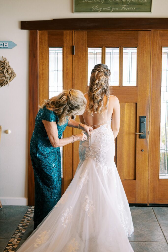 Mom helping button up bride's wedding dress by Cayucos Wedding Photographer on Film by Austyn Elizabeth Photography