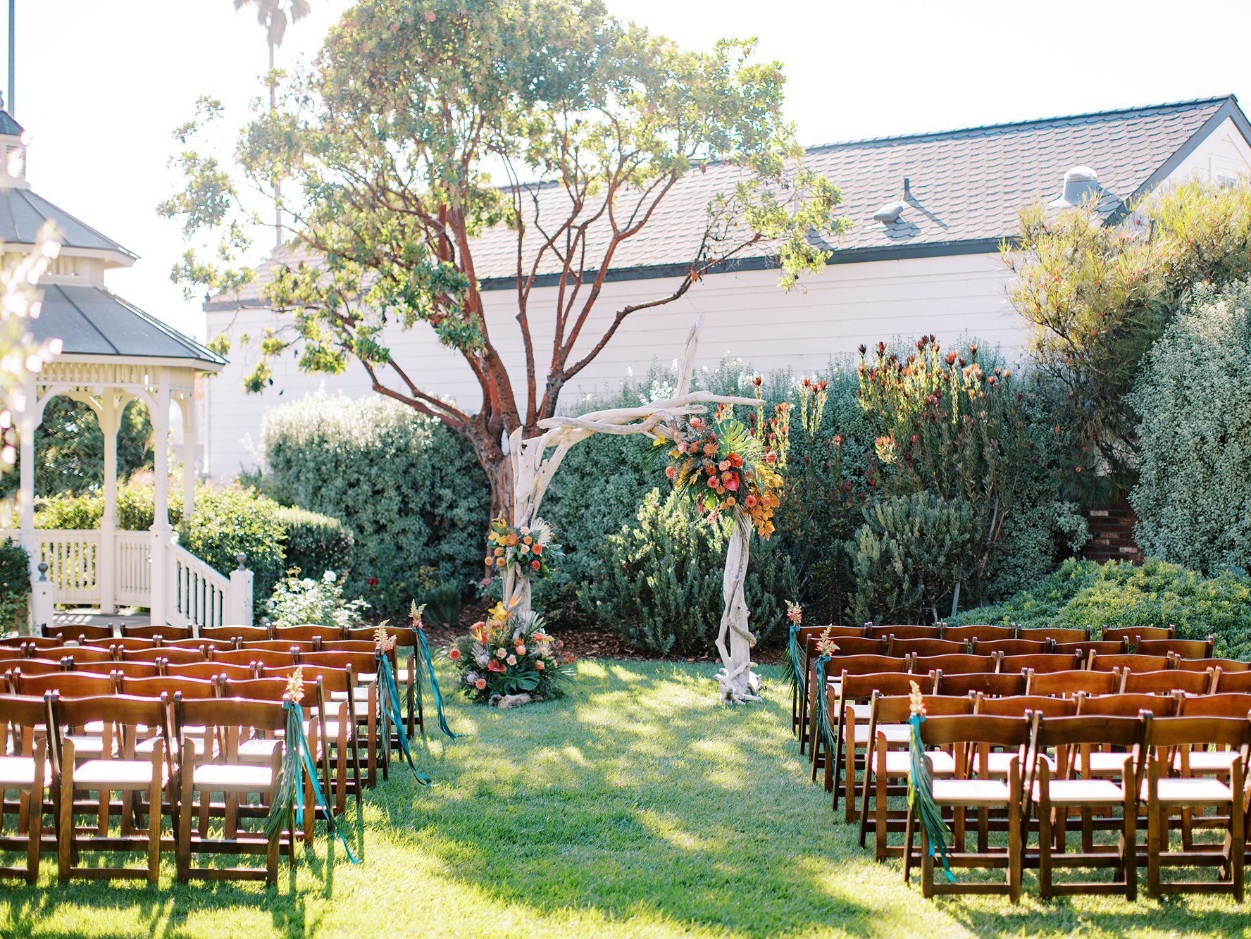 Wedding ceremony with driftwood arbor and tropical bright flowers by Cayucos Wedding Photographer on Film by Austyn Elizabeth Photography