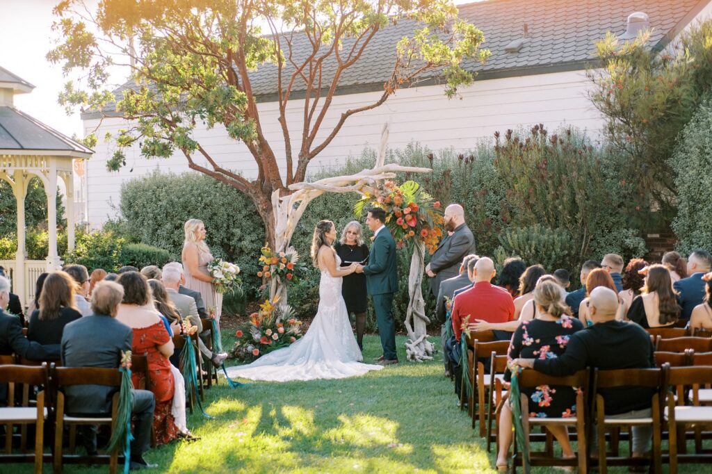 Bride and groom hold hands during wedding ceremony by Cayucos Wedding Photographer on Film by Austyn Elizabeth Photography