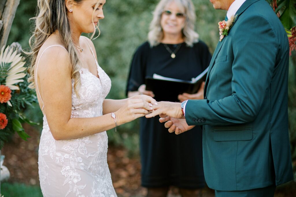 Bride puts ring on groom in teal tux by San Luis Obispo wedding photographer Austyn Elizabeth Photography