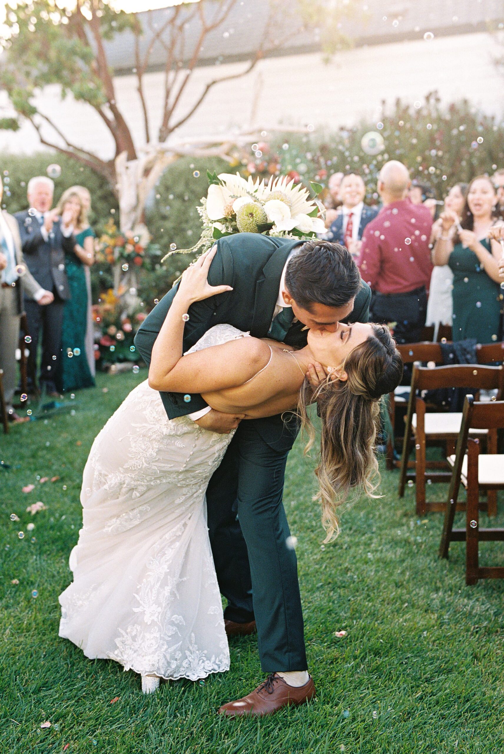 Groom dips bride in middle of aisle with balloons by Cayucos Wedding Photographer on Film by Austyn Elizabeth Photography