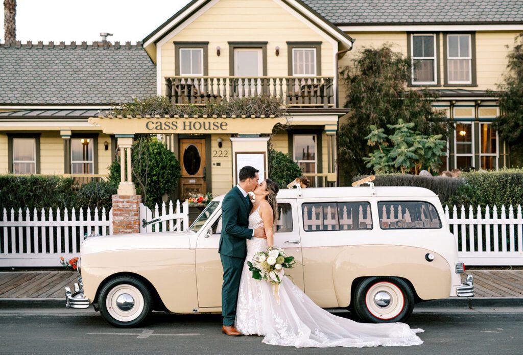 Couple kiss in front of tiki car and Cass House by Cayucos Wedding Photographer on Film by Austyn Elizabeth Photography