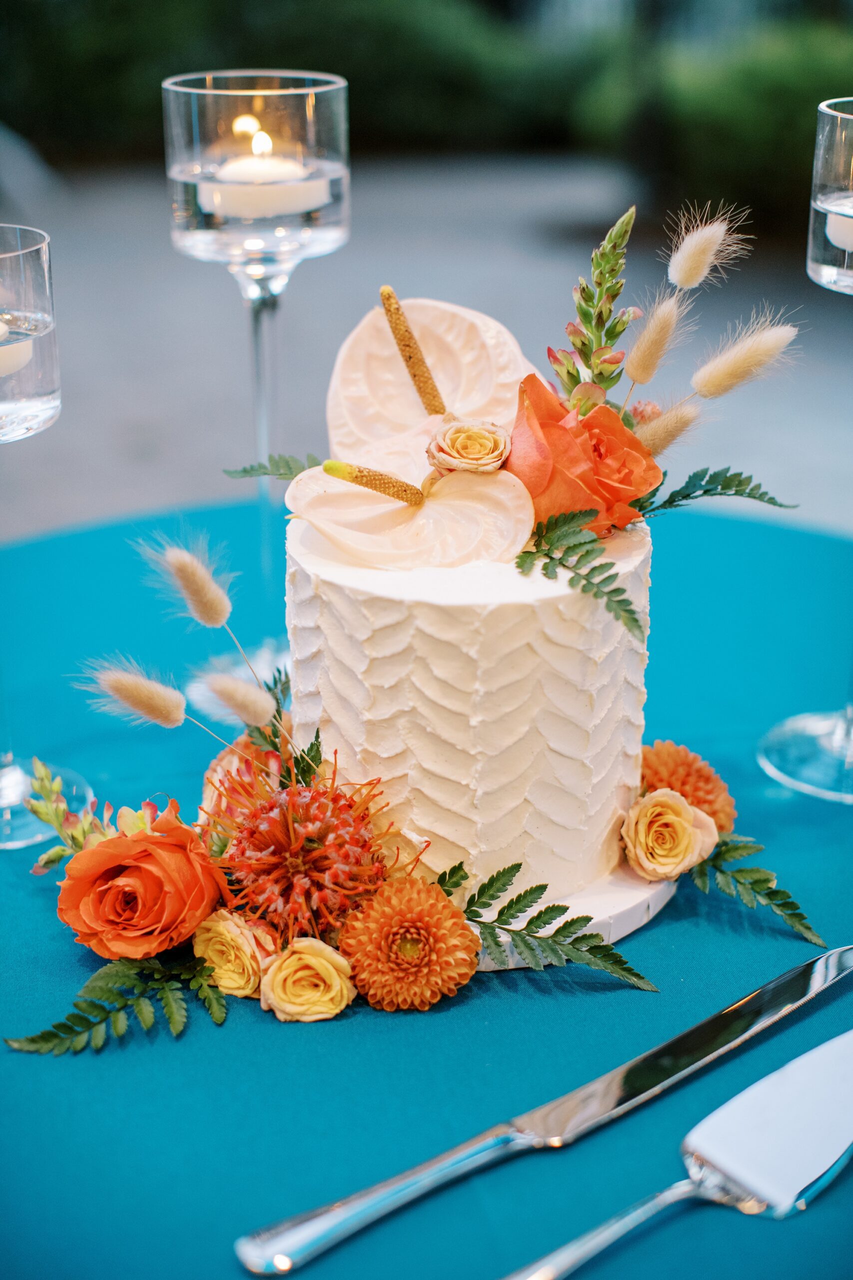 Chevron cake cutting design with tropical pinks peach and gold flowers on teal table by Cayucos Wedding Photographer on Film by Austyn Elizabeth Photography