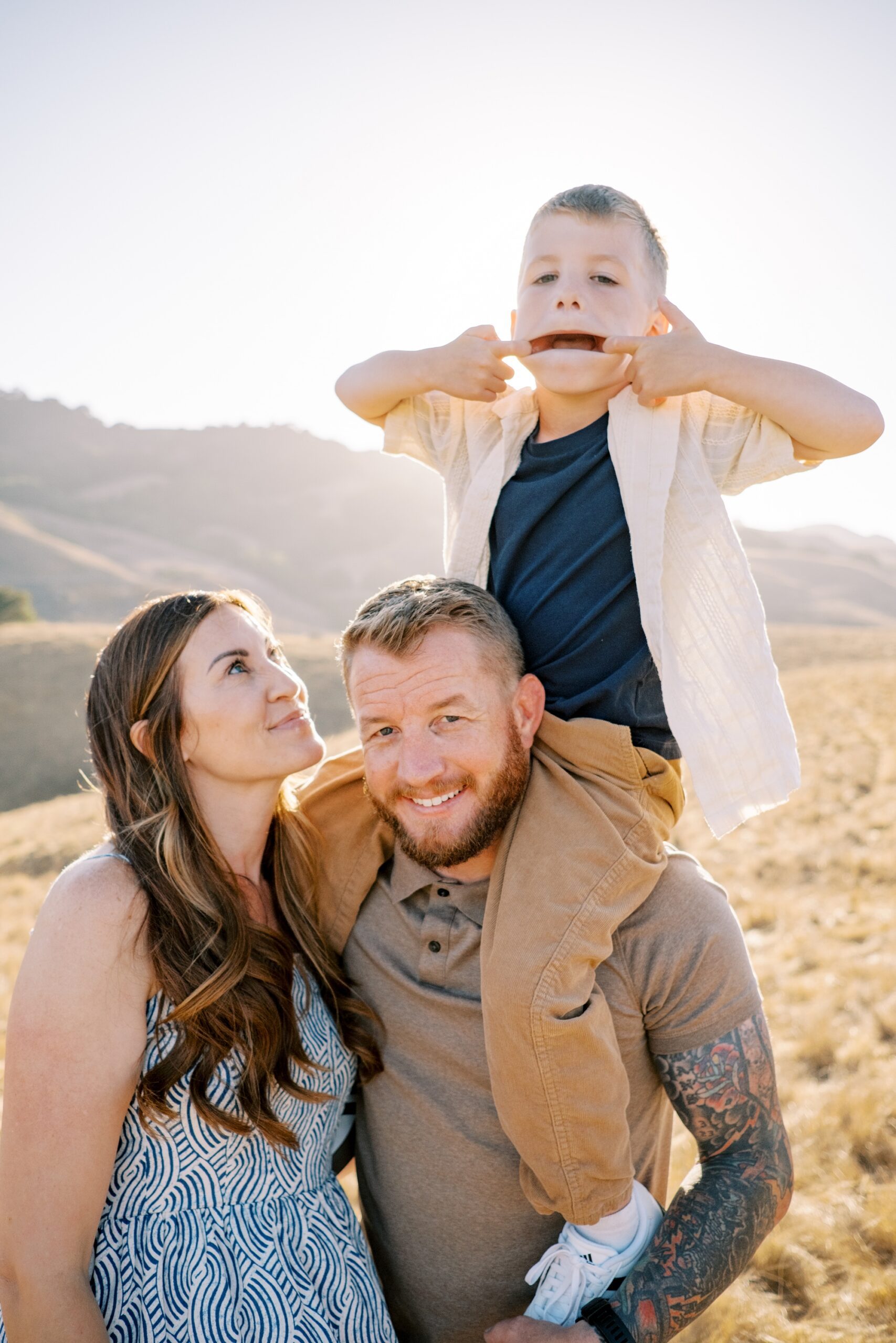 Little boy making faces sitting on dad's shoulders in San Luis Obispo Family Photos at Johnson Ranch Trail by Pismo Beach Family Photographer Austyn Elizabeth Photography