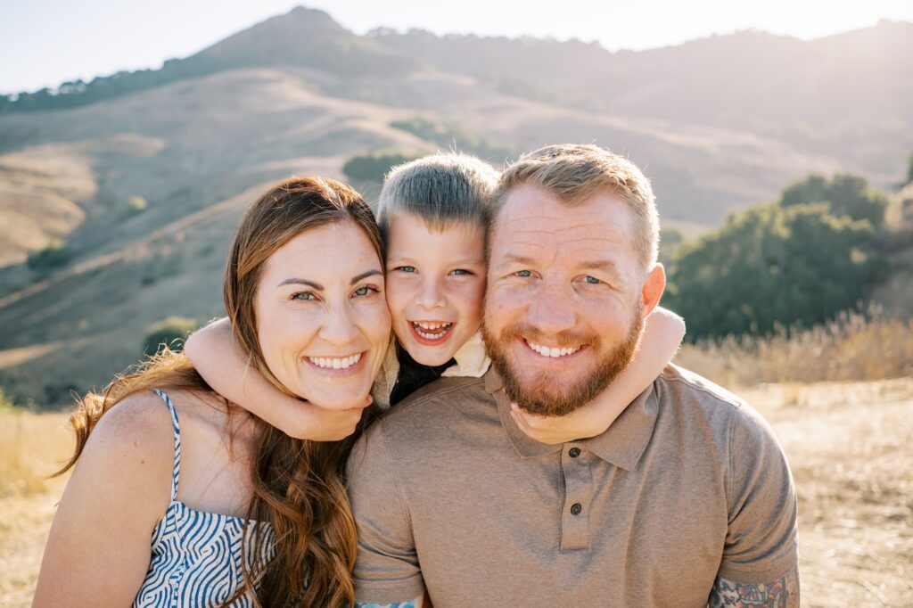 Six year old hugs mom and dad at Johnson Ranch Trail by Pismo Beach Family Photographer Austyn Elizabeth Photography