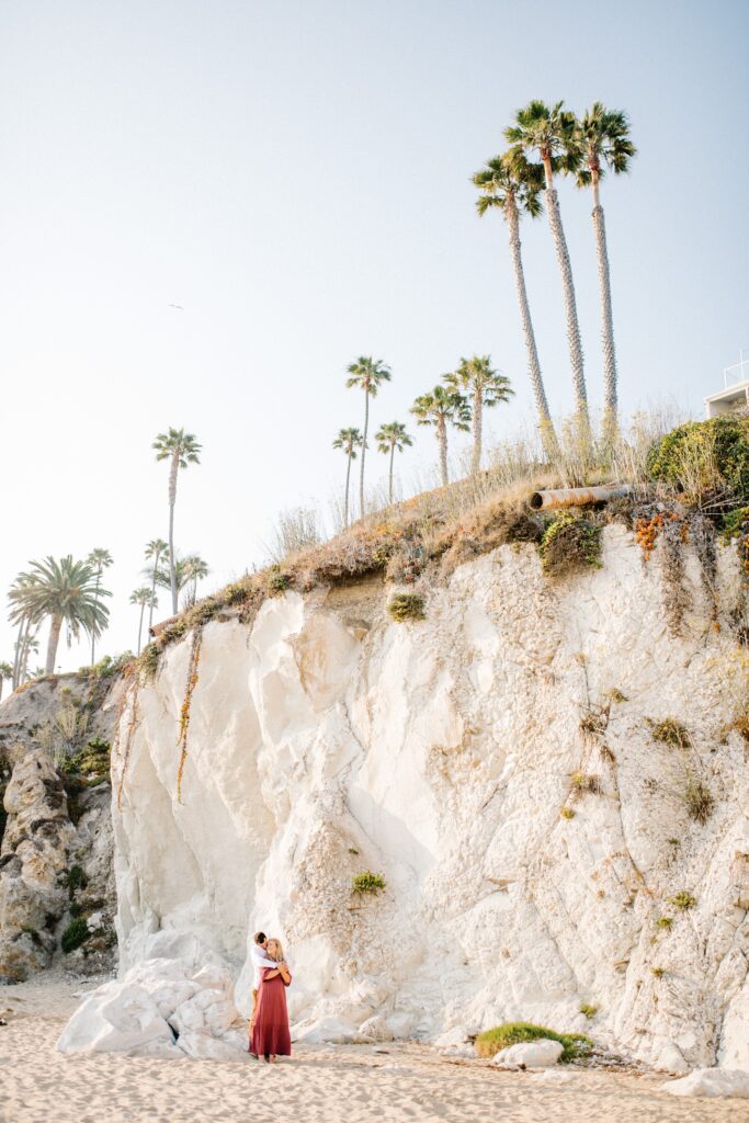 Standing beneath white pismo beach cliffs by Pismo Beach Engagement Photographer Austyn Elizabeth Photography