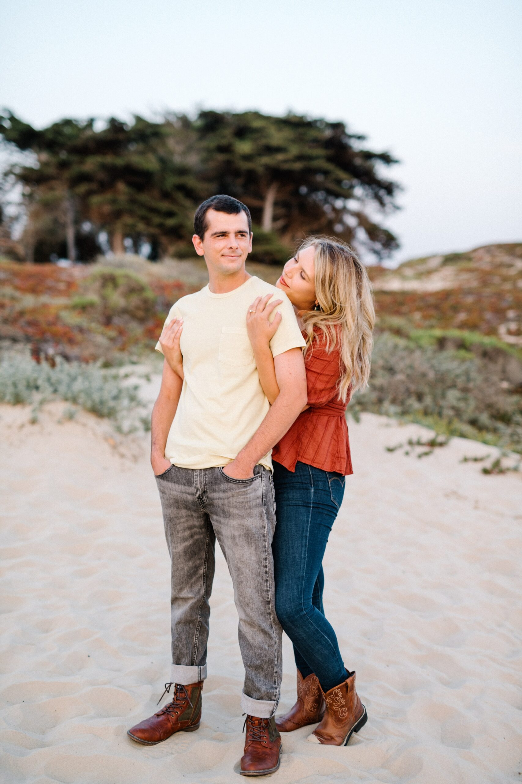Couple stand looking at the ocean during sunset by Pismo Beach Engagement Photographer Austyn Elizabeth Photography
