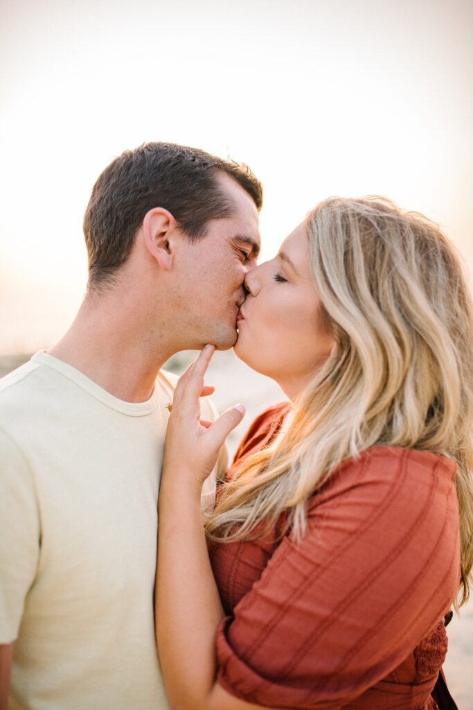 Bride lifts groom's chin by Pismo Beach Engagement Photographer Austyn Elizabeth Photography