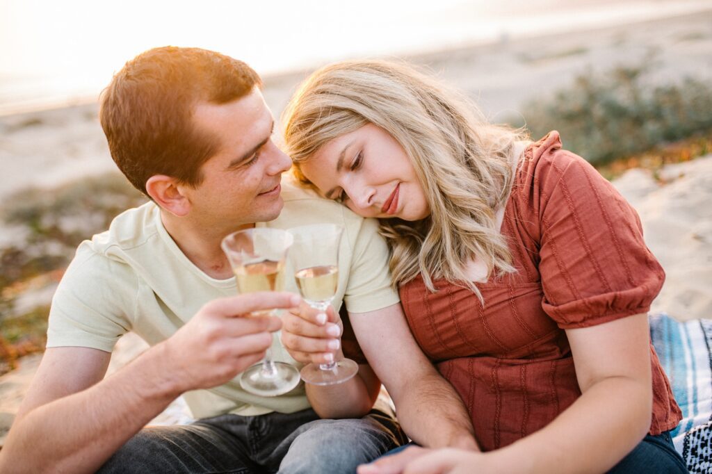 Couple toast during engagement session on the beach by Pismo Beach Engagement Photographer Austyn Elizabeth Photography