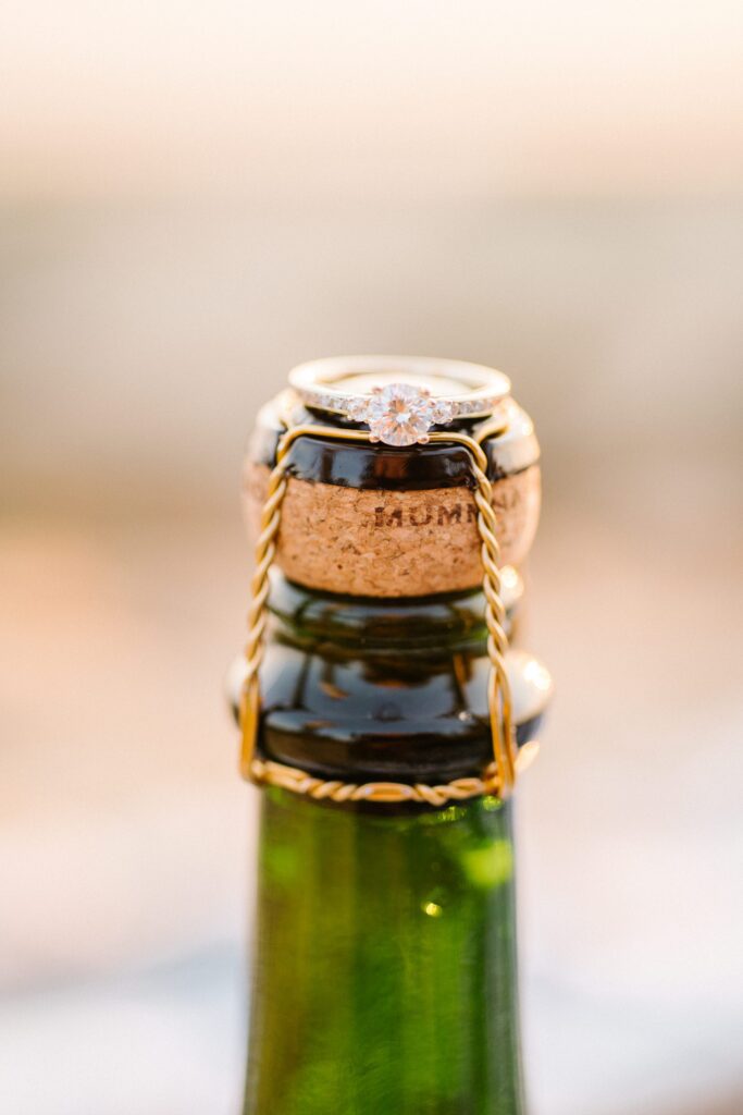 Engagement ring on champagne bottle by Pismo Beach Engagement Photographer Austyn Elizabeth Photography
