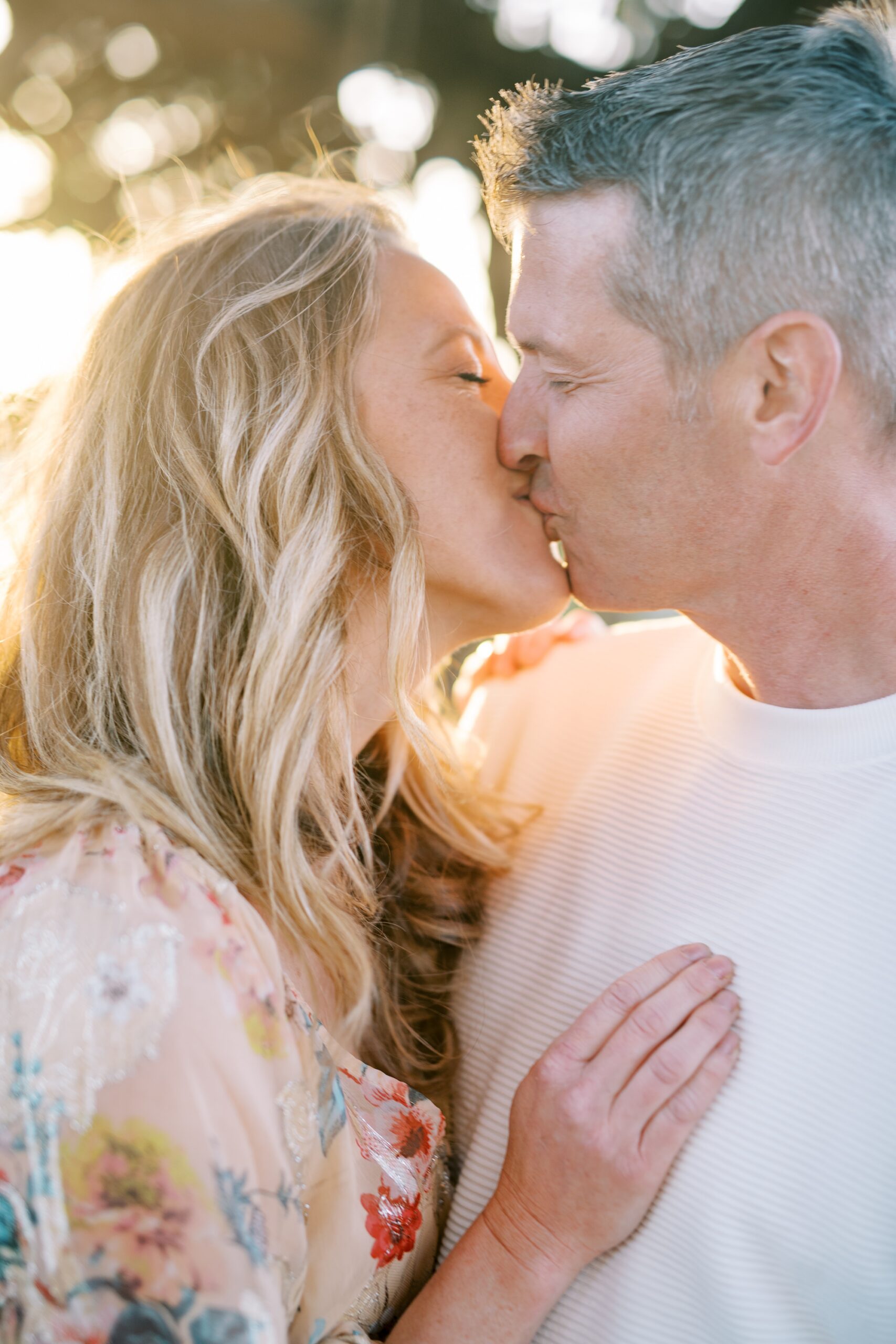 Mom and dad take a mom and kiss during golden hour by Pismo Beach Family Photographer Austyn Elizabeth Photography