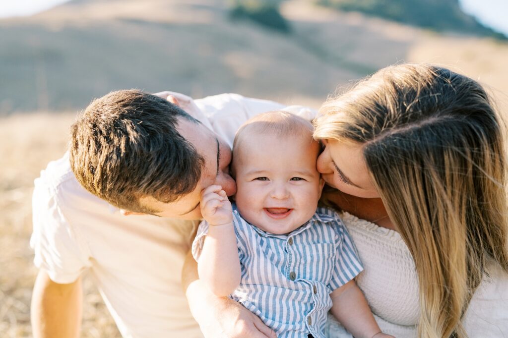 Parents in cream colored clothes and baby in striped blue and white shirt at Bishop Peak family photos by San Luis Obispo Family Photographer Austyn Elizabeth Photography 
